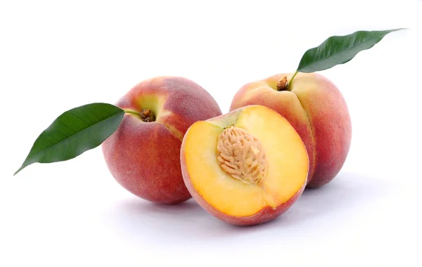 Персики півтора і листя — стокове фото