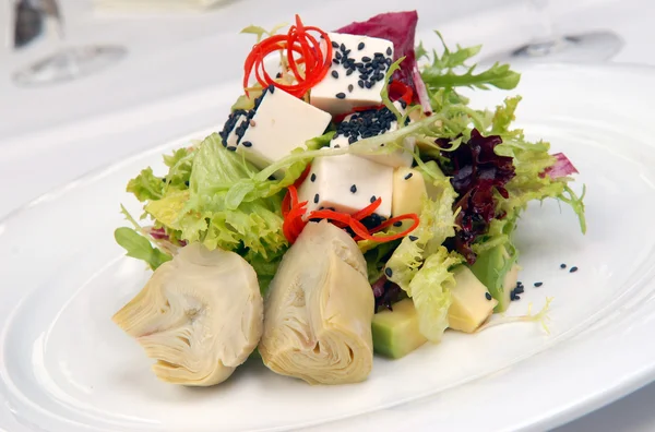 Salad with a crude and artichokes — Stock Photo, Image