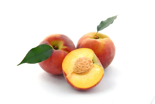 Peaches and a half and leaves — Stock Photo, Image