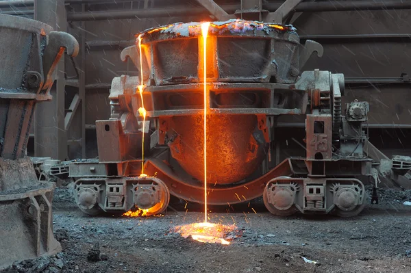 Das geschmolzene Metall strömt aus einer Schöpfkelle — Stockfoto