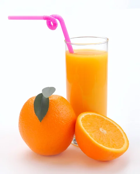 Χυμό πορτοκαλιού σε ένα ποτήρι και ένα πορτοκάλι — Φωτογραφία Αρχείου