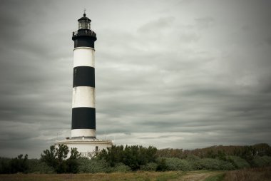 Lighthouse under cloudy sky clipart