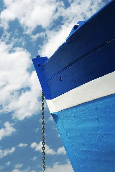 Цепочка из белой и синей деревянной лодки — стоковое фото