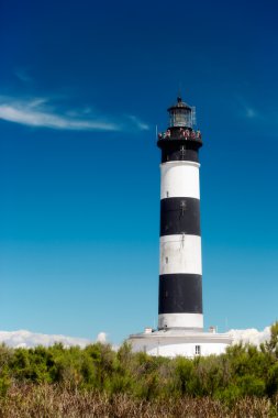 Lighthouse under blue sky clipart