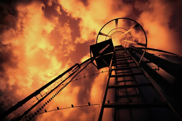 Raffinerie-Leiter unter bösem Himmel — Stockfoto