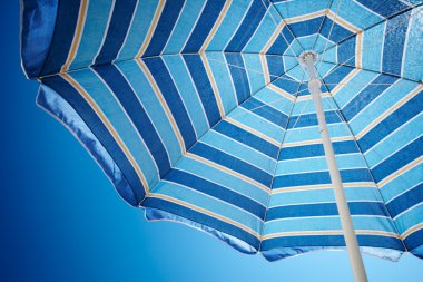 Parasol against deep blue sky clipart