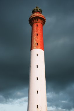 Lighthouse with stormy clouds clipart