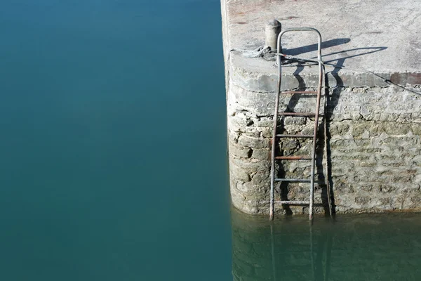 Стена гавани со стальной лестницей — стоковое фото