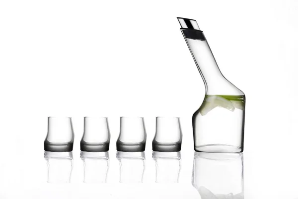 Une bouteille d'eau et quatre tasse en verre Photo De Stock