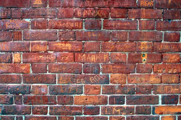 Graffiti preenchido parede de tijolo vermelho . Imagens Royalty-Free