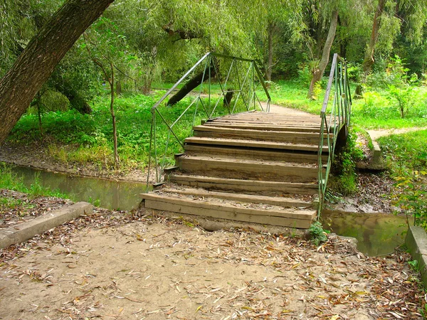 Vanha silta pienen joen yli puistossa — kuvapankkivalokuva