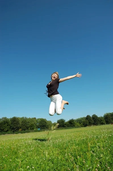 Прыгающая молодая счастливая девушка — стоковое фото