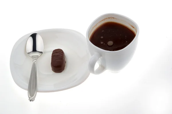 Tazza di caffè caldo con cucchiaio e caramelle al cioccolato — Foto Stock