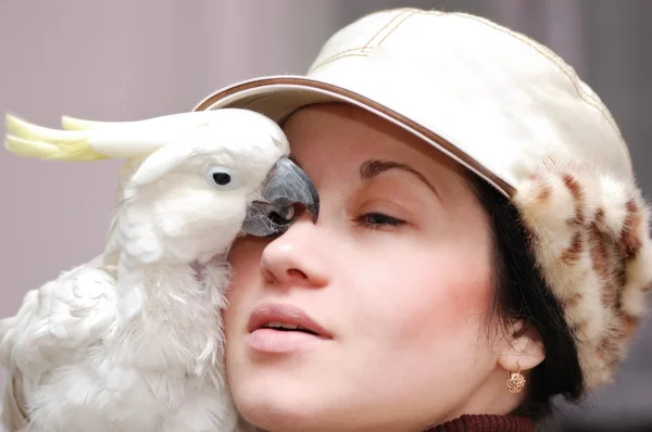 Girl with kissing parrot — Stock Photo, Image