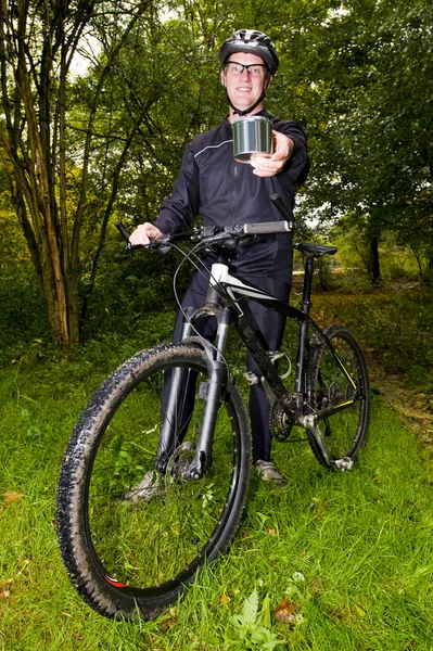 Mountain biker showing a tin can — Stock Photo, Image
