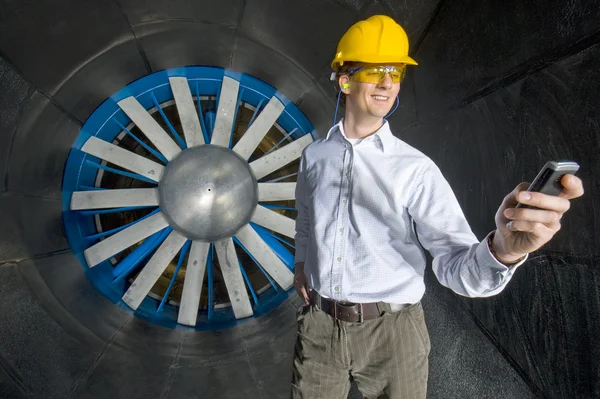 A smiling engineer, looking at his phone — Stock Photo, Image