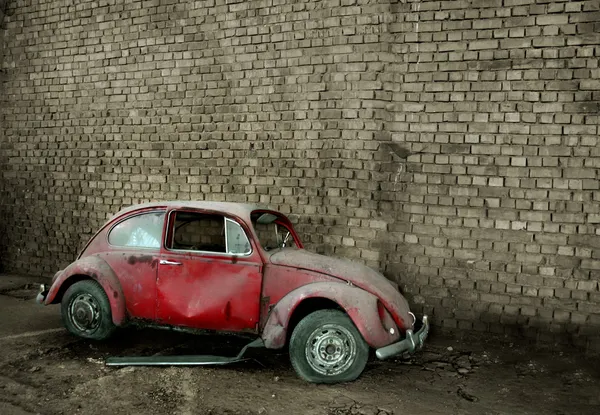 Grunge carro na frente de uma parede de tijolo — Fotografia de Stock