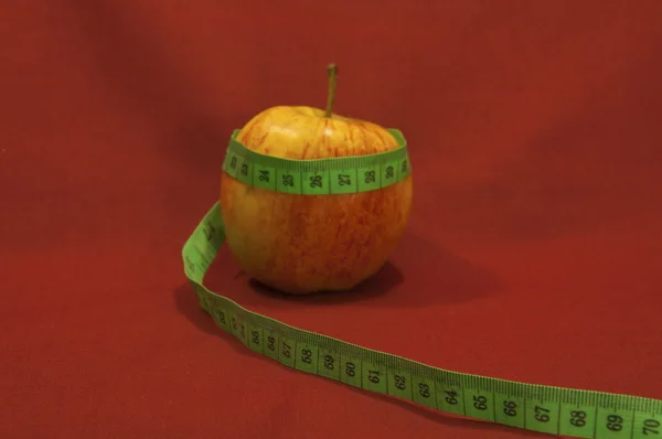 Stock image Apple wrapped by tailor measuring tape