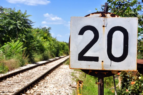 Railway sign meaning beginning of speed limit stretch at railroad  embankment with rail track disappearing in mist in background Stock Photo -  Alamy