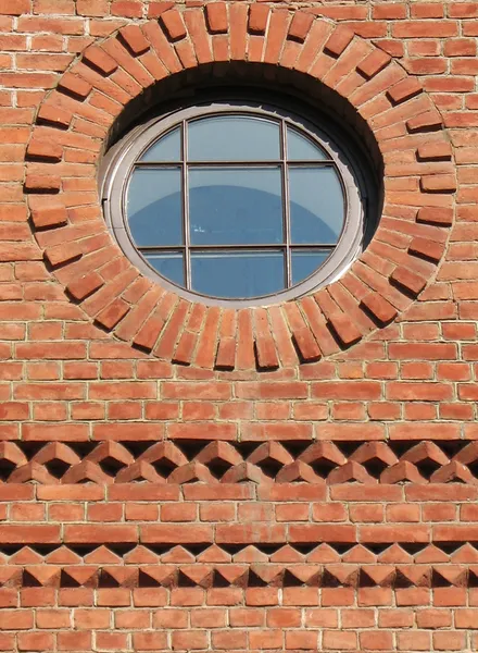 Кирпичная стена с круглым окном — стоковое фото