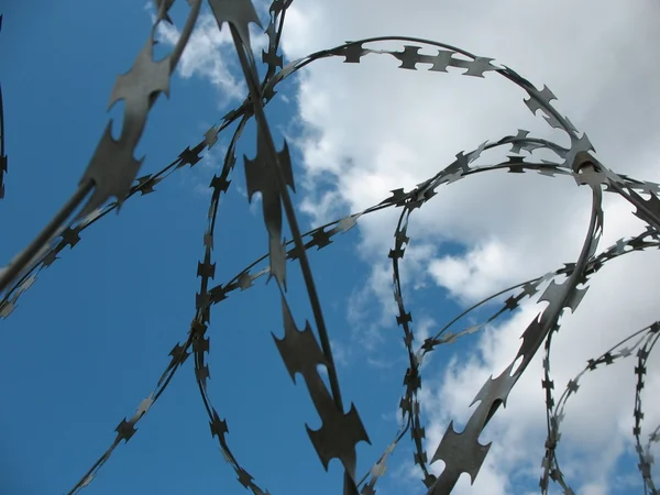Barbwire and wall under blue sky — Stock Photo, Image