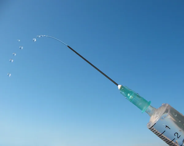 stock image Disposable syringe against the blue sky