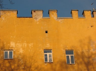 Sarı duvarlar ve siyah çıplak ağaçlar