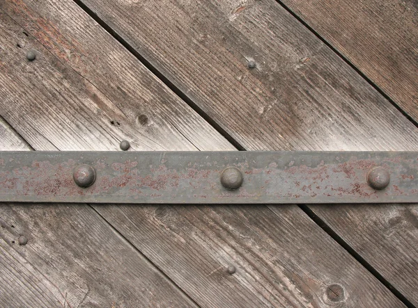 Porta de madeira velha com uma tira de ferro — Fotografia de Stock