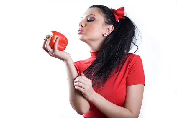 Leuk meisje in een rode jurk met paprika — Stockfoto