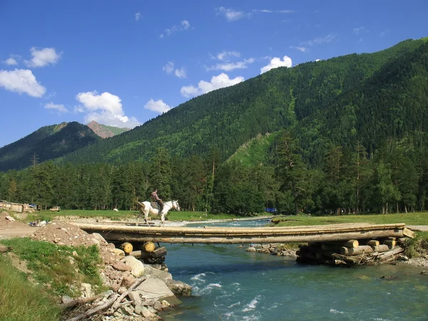 A ponte no rio da montanha — Fotografia de Stock