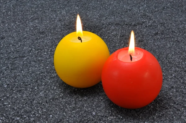 Burning candles in grey sand — Stock Photo, Image