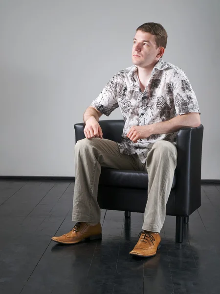 黒い肘掛け椅子の男 — ストック写真