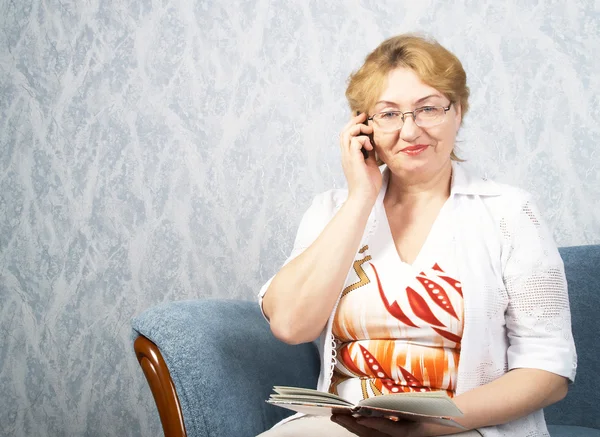 De volwassen vrouw met telefoon — Stockfoto