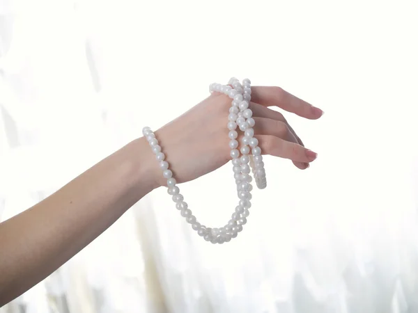 Mano femminile con perle — Foto Stock