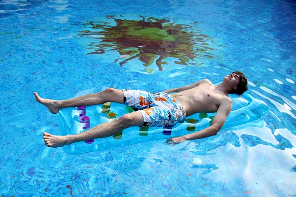 O jovem flutua na piscina — Fotografia de Stock