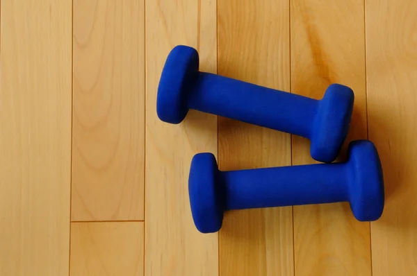Blaue Gewichte auf Hartholzboden — Stockfoto