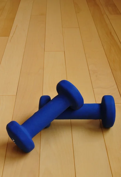 Blaue Gewichte auf Hartholzboden — Stockfoto