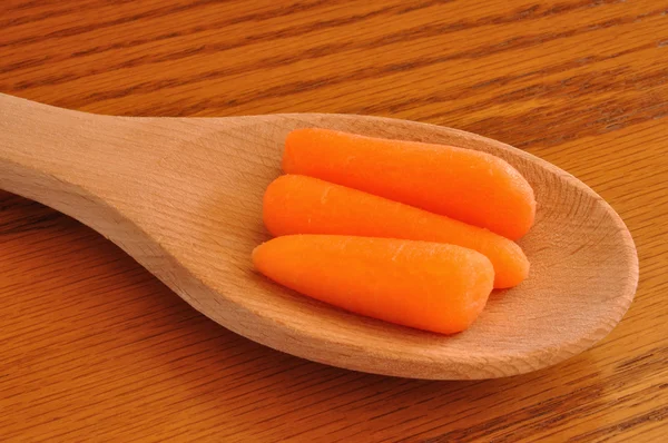 Zanahorias bebé en una cuchara de madera — Foto de Stock