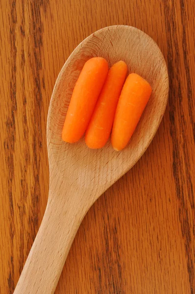 Τα καρότα μωρό, σχετικά με ένα ξύλινο κουτάλι — Φωτογραφία Αρχείου