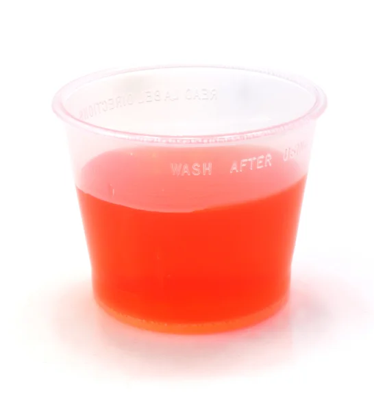 Jarabe de tos roja en una taza — Foto de Stock