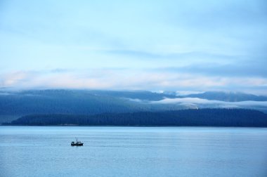 Fishing Boat with Mountains,Low Clouds clipart