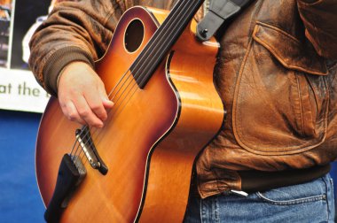 Adam akustik bas gitar çalıyor.