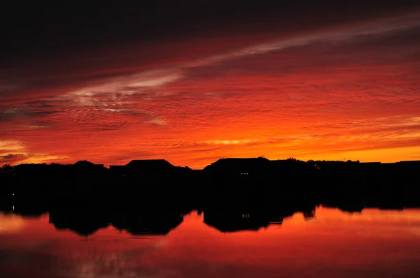Siluety lake domy při západu slunce — Stock fotografie