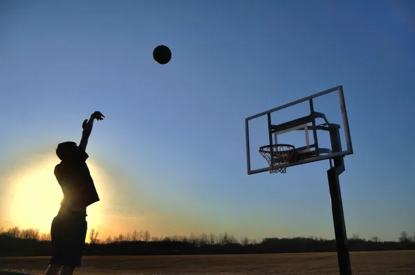 Silhueta de adolescente e basquete — Fotografia de Stock