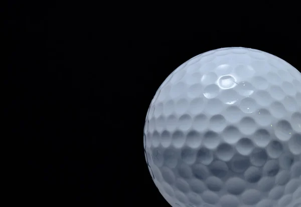 Golfball mit schwarzem Hintergrund — Stockfoto