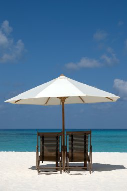 Chairs on the beach in Maldives clipart