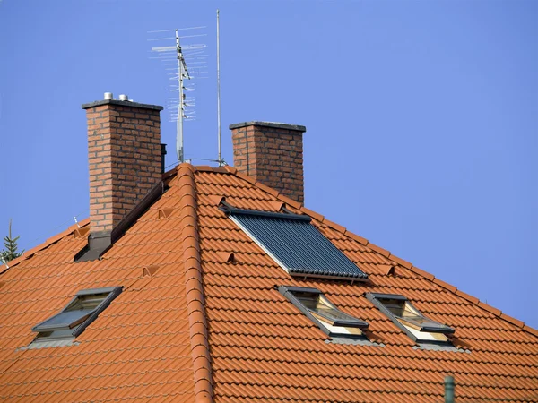 Dach z dwóch kominów i kolektorów słonecznych — Zdjęcie stockowe