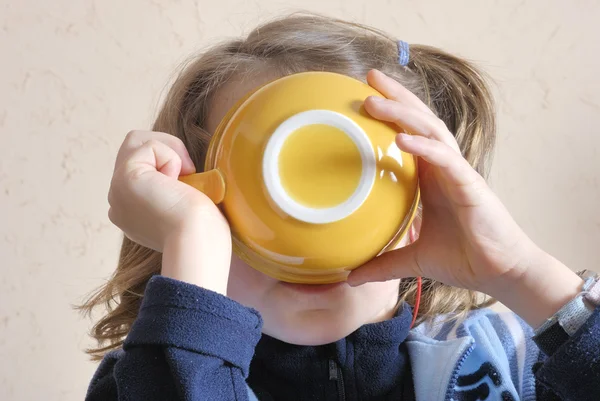 Girl drinking from bowl — Stock Photo, Image