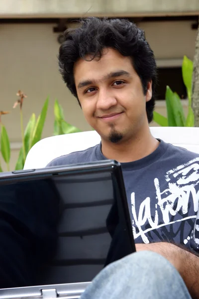 Genç adam bir dizüstü bilgisayar kullanarak — Stok fotoğraf