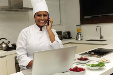 Chef cooking in kitchen talking on phone clipart